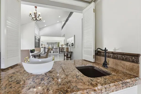 a large white kitchen with a large window and sink
