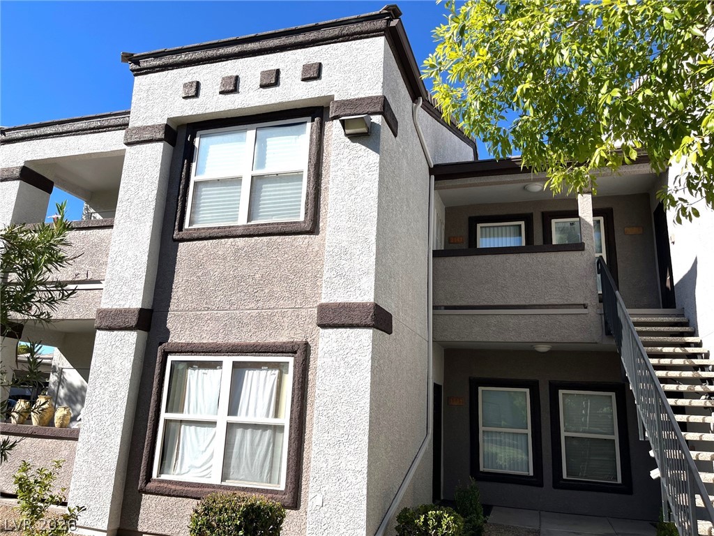 7255 West Sunset Road, Unit 2141 Las Vegas, NV 89113 - Photo 11 of 15 Multi-level stucco exterior showcases dark trim accents and an open staircase design.