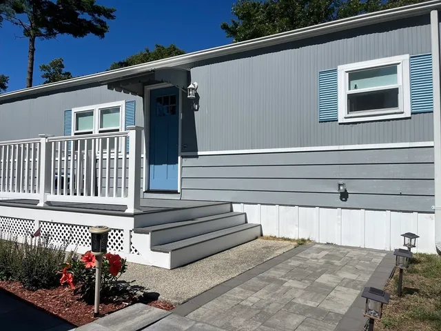 a view of a house with a small yard and potted plants