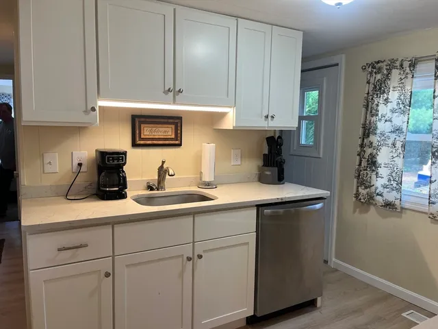a kitchen with stainless steel appliances granite countertop a sink a stove and cabinets