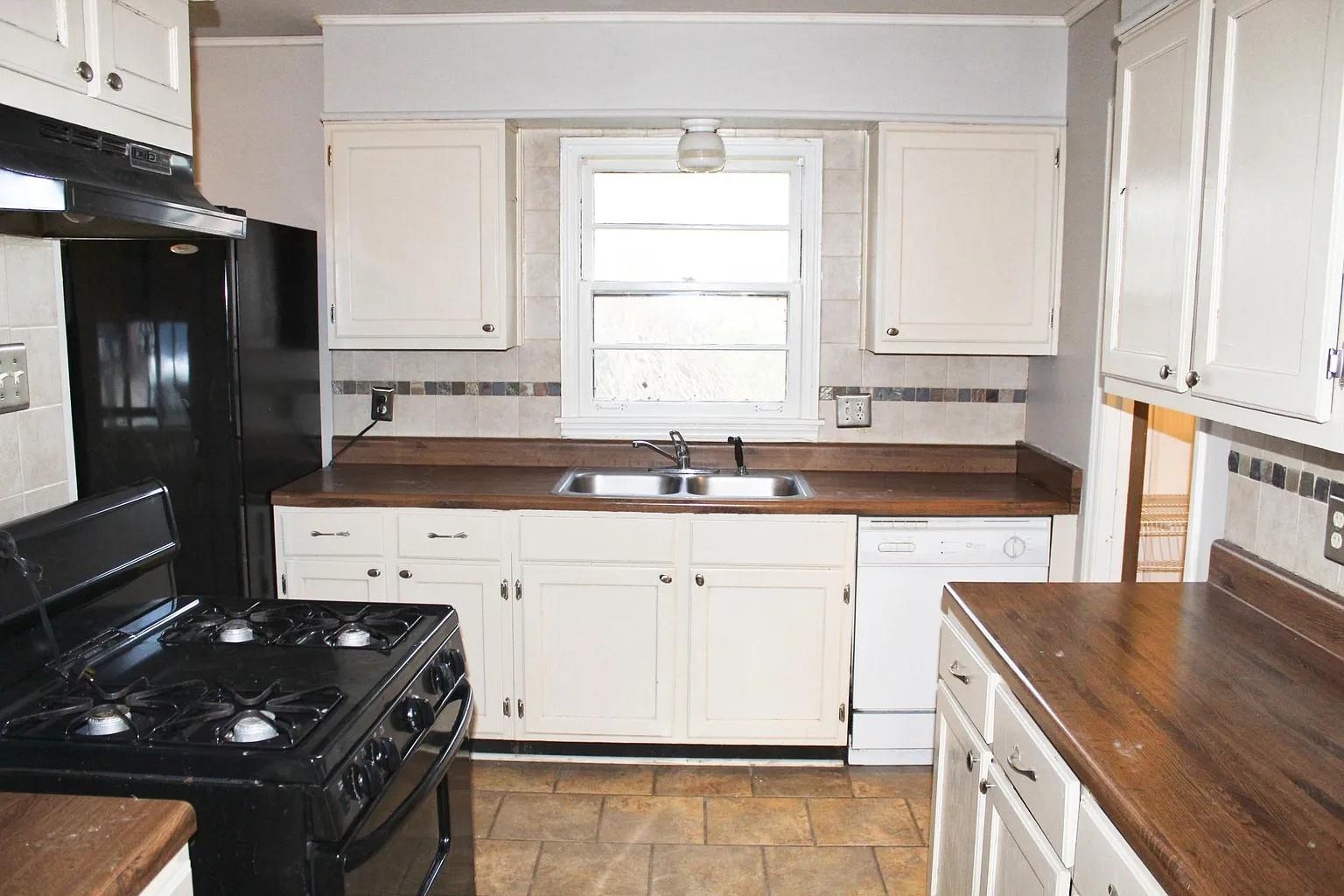 1606 Sea Isle Road Memphis, TN 38117 - Photo 4 of 7 a kitchen with granite countertop a sink stove and cabinets