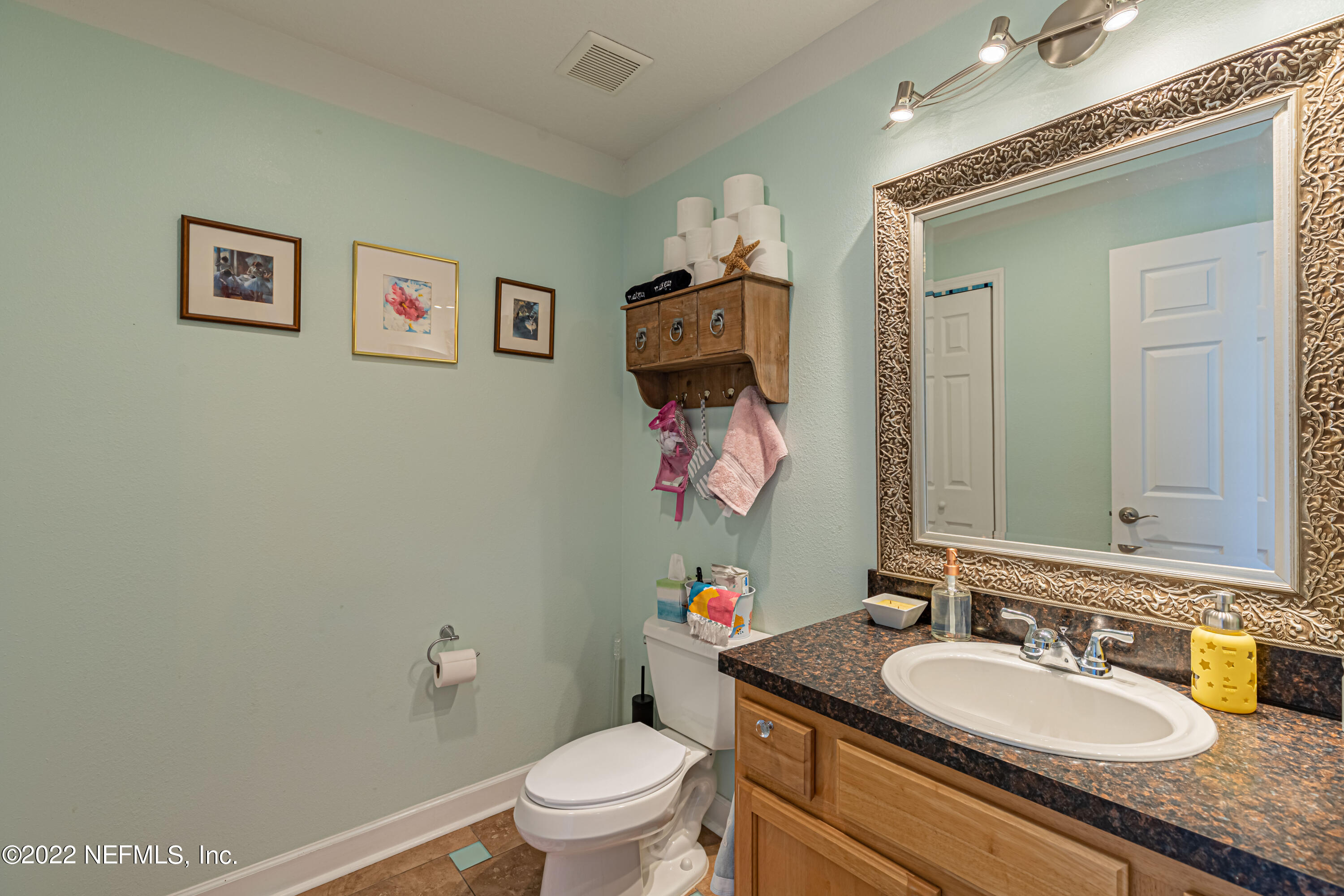 1830 Bennett Road St. Augustine, FL 32092 - Photo 22 of 45 a bathroom with a granite countertop sink mirror vanity and toilet