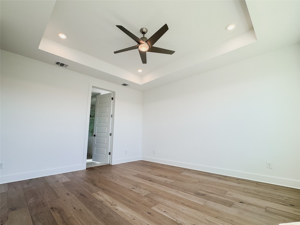 712 Iron Willow Loop Dripping Springs, TX 78620 - Photo 13 of 30 an empty room with wooden floor and a ceiling fan