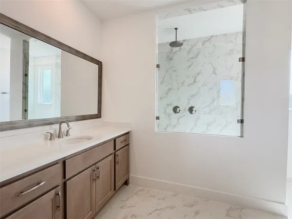 a bathroom with a double vanity sink mirror and shower