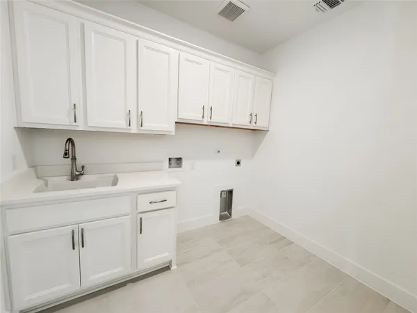 a kitchen with white cabinets and sink