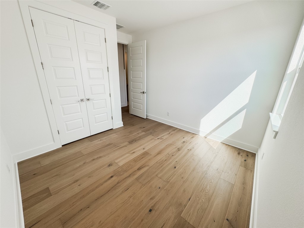 712 Iron Willow Loop Dripping Springs, TX 78620 - Photo 19 of 30 an empty room with wooden floor and cabinet