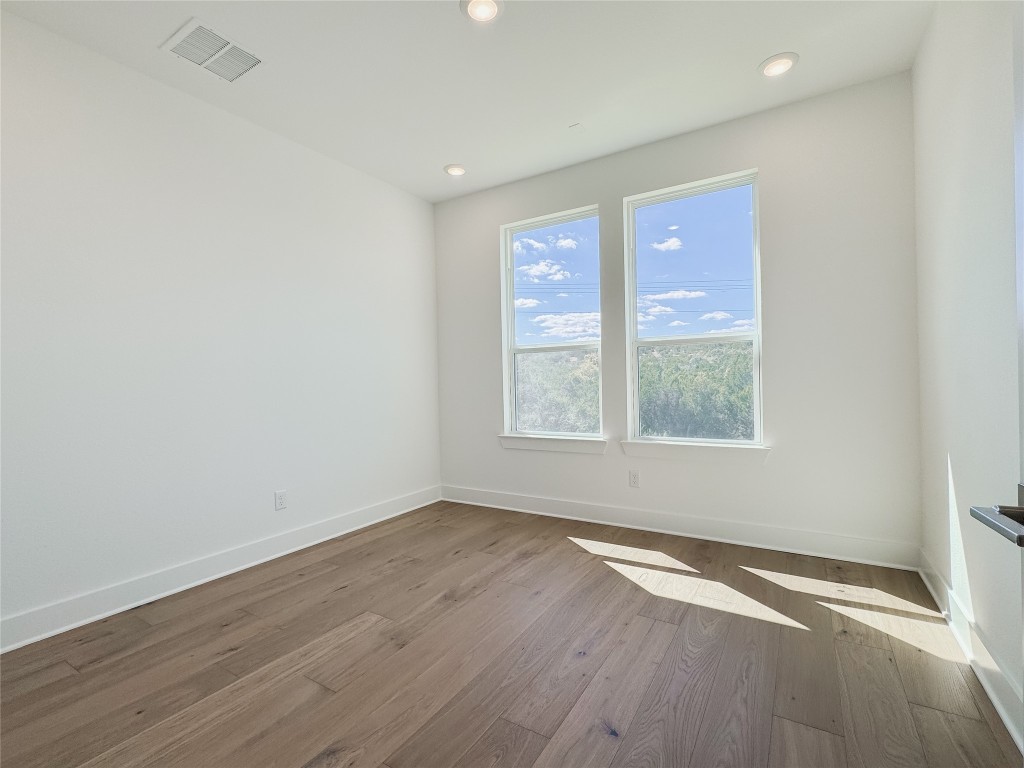 712 Iron Willow Loop Dripping Springs, TX 78620 - Photo 21 of 30 an empty room with wooden floor and windows