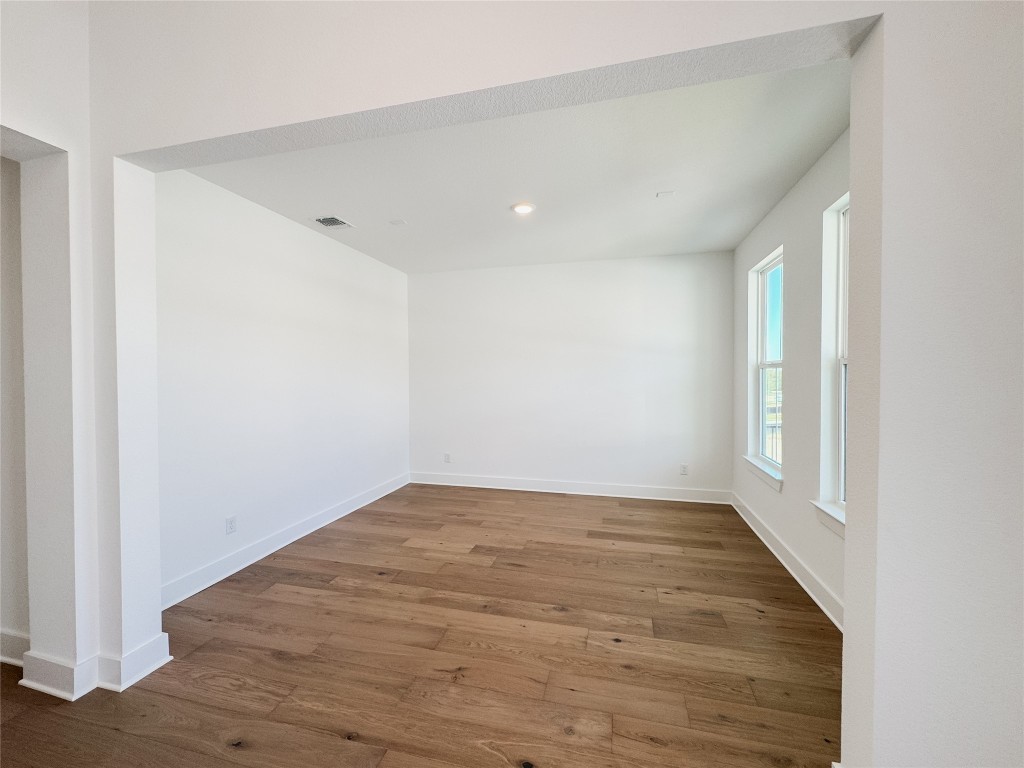 712 Iron Willow Loop Dripping Springs, TX 78620 - Photo 4 of 30 wooden floor in an empty room with a window