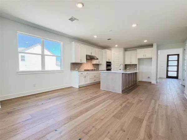 a view of a kitchen with wooden floor and electronic appliances