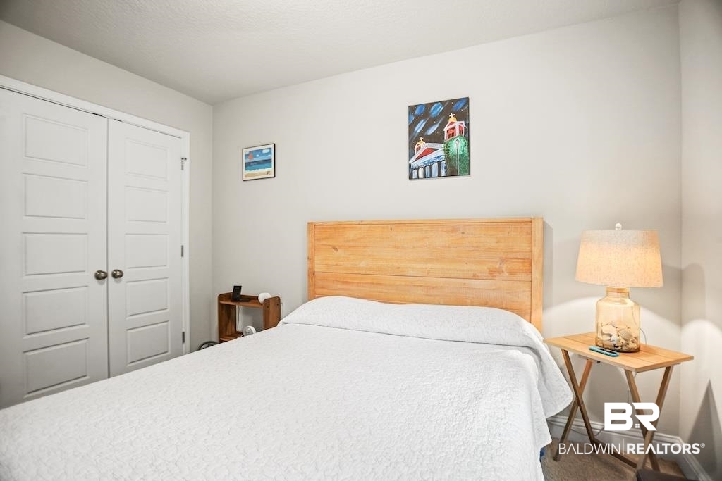 25806 Pollard Road, Unit 27 Daphne, AL 36526 - Photo 37 of 46 Bedroom with a closet and carpet flooring