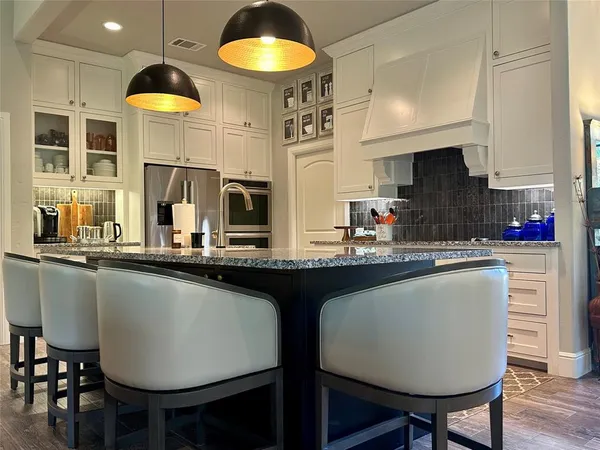 a kitchen with a table chairs sink and cabinets
