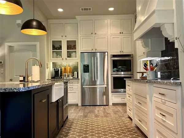 a kitchen with a sink stainless steel appliances and white cabinets