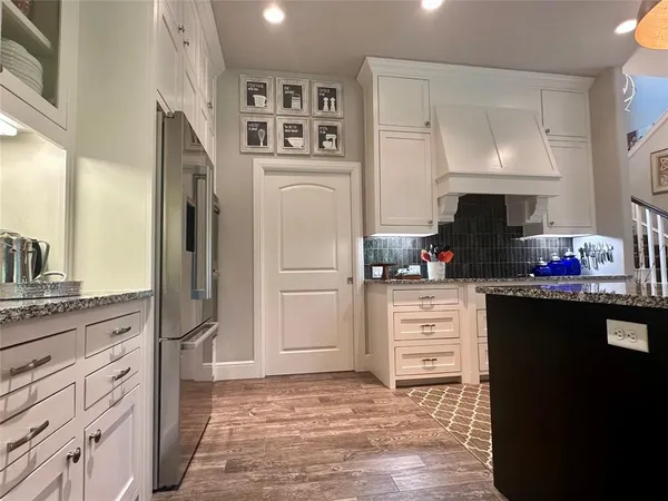 a kitchen with white cabinets and refrigerator