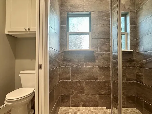 a bathroom with a toilet and a shower
