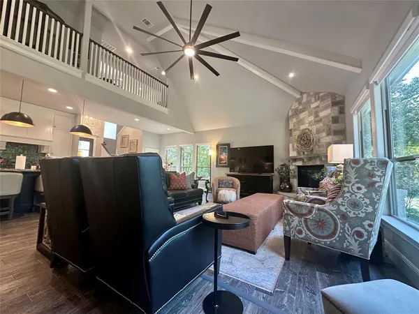 a living room with furniture a fireplace and a large window