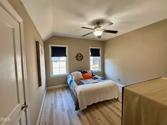 a bedroom with a bed window and chair