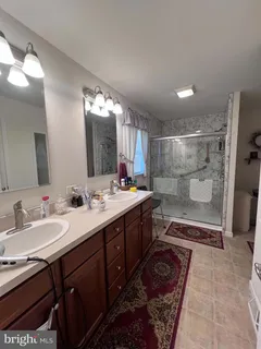 a bathroom with a double vanity sink mirror double and shower