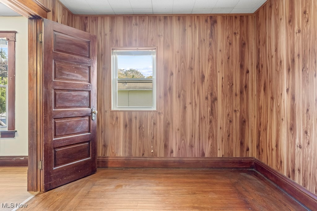 2725 Linwood Road Akron, OH 44312 - Photo 22 of 38 Spare room featuring wood walls and light hardwood / wood-style flooring