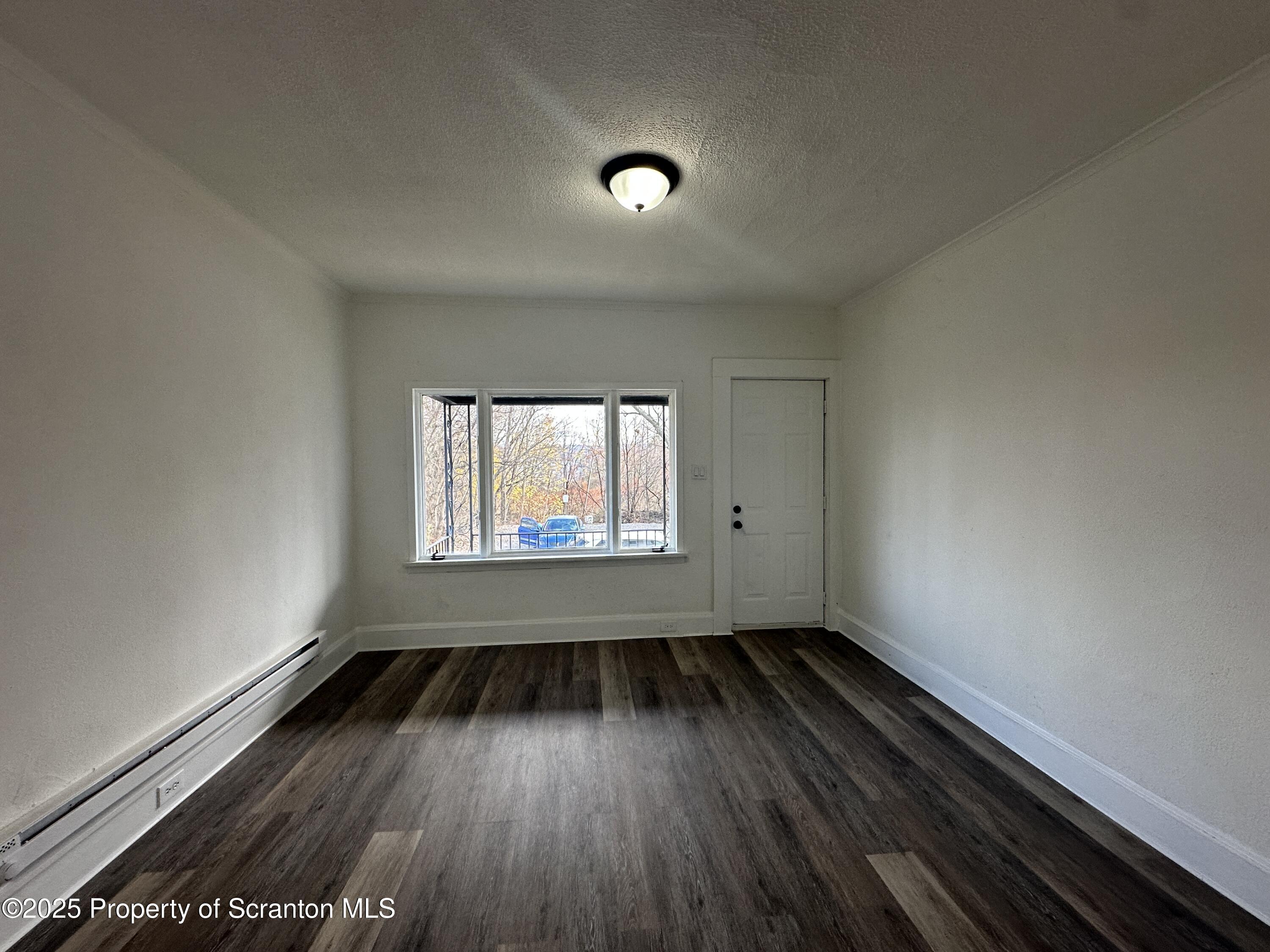 1262 South 6th Avenue Scranton, PA 18504 - Photo 2 of 8 an empty room with wooden floor and windows