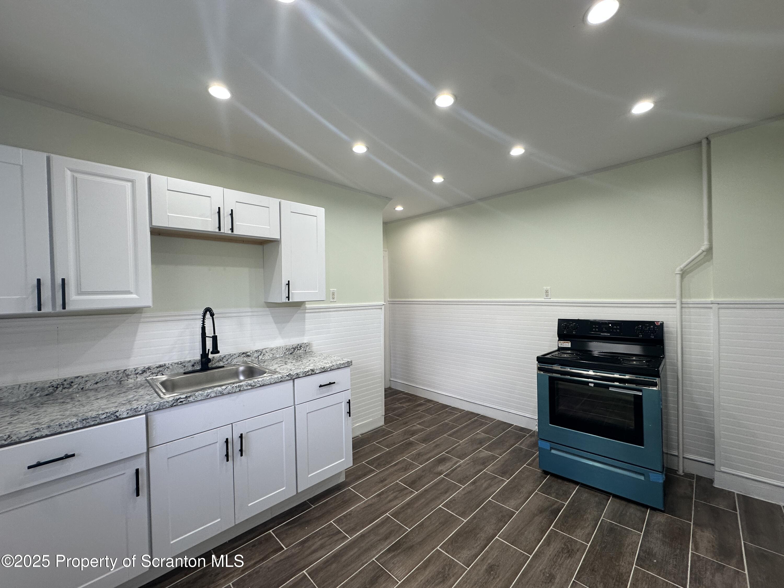 1262 South 6th Avenue Scranton, PA 18504 - Photo 5 of 8 a kitchen with granite countertop a stove and a refrigerator