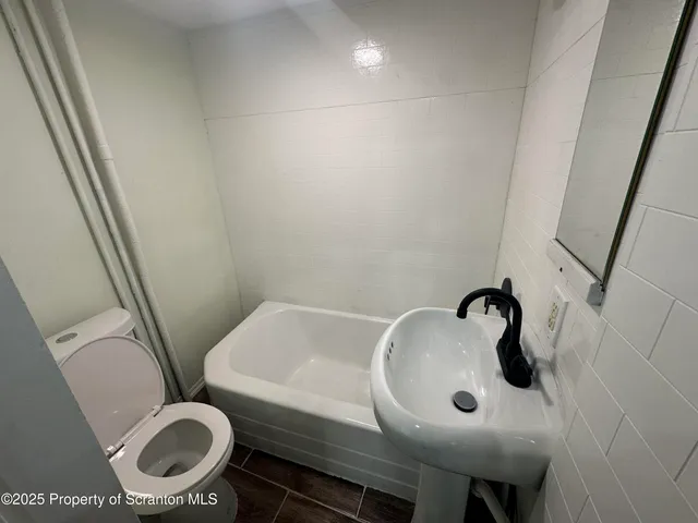 a view of house with wooden deck and furniture