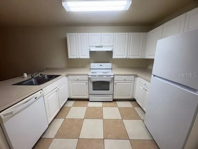 a kitchen with a stove sink and cabinets