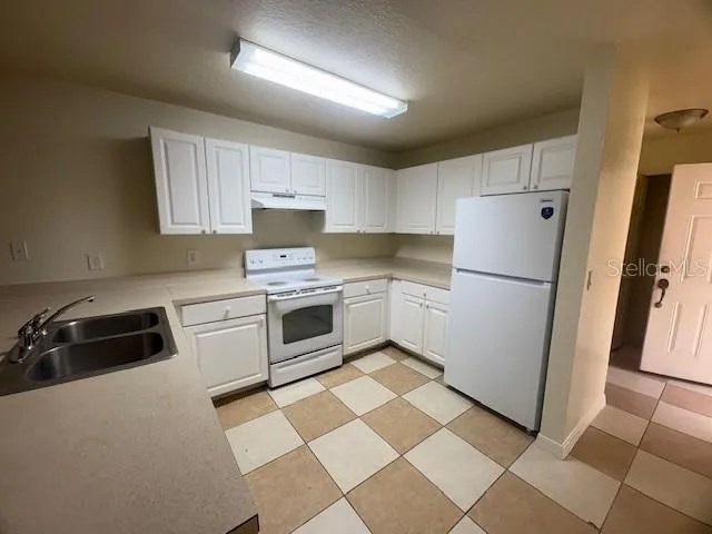 a kitchen with a refrigerator a stove a sink a washer and dryer