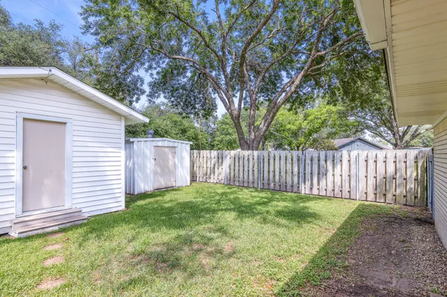 a view of a backyard with a small cabin and wooden fence