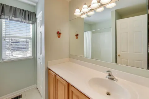 a bathroom with a sink vanity and a mirror