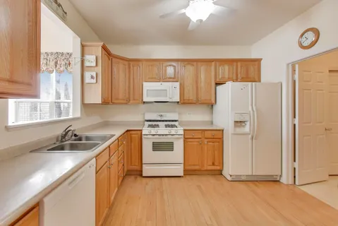 a kitchen with stainless steel appliances granite countertop a refrigerator a sink and a stove