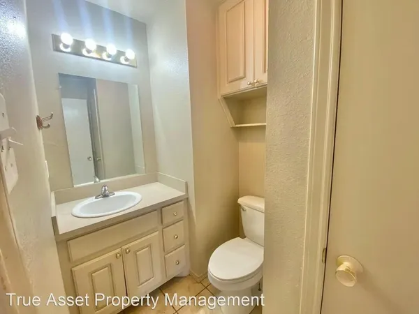 a bathroom with a granite countertop sink toilet and a mirror
