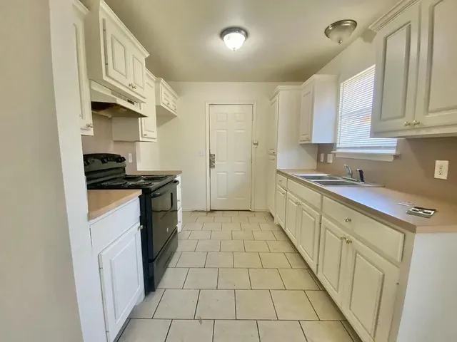 a view of a hallway with wooden floor and chandelier