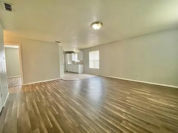 wooden floor in an empty room with a window