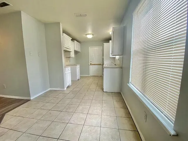 a view of a kitchen with a sink and an empty room