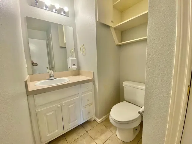 a bathroom with a toilet a sink a vanity and mirror