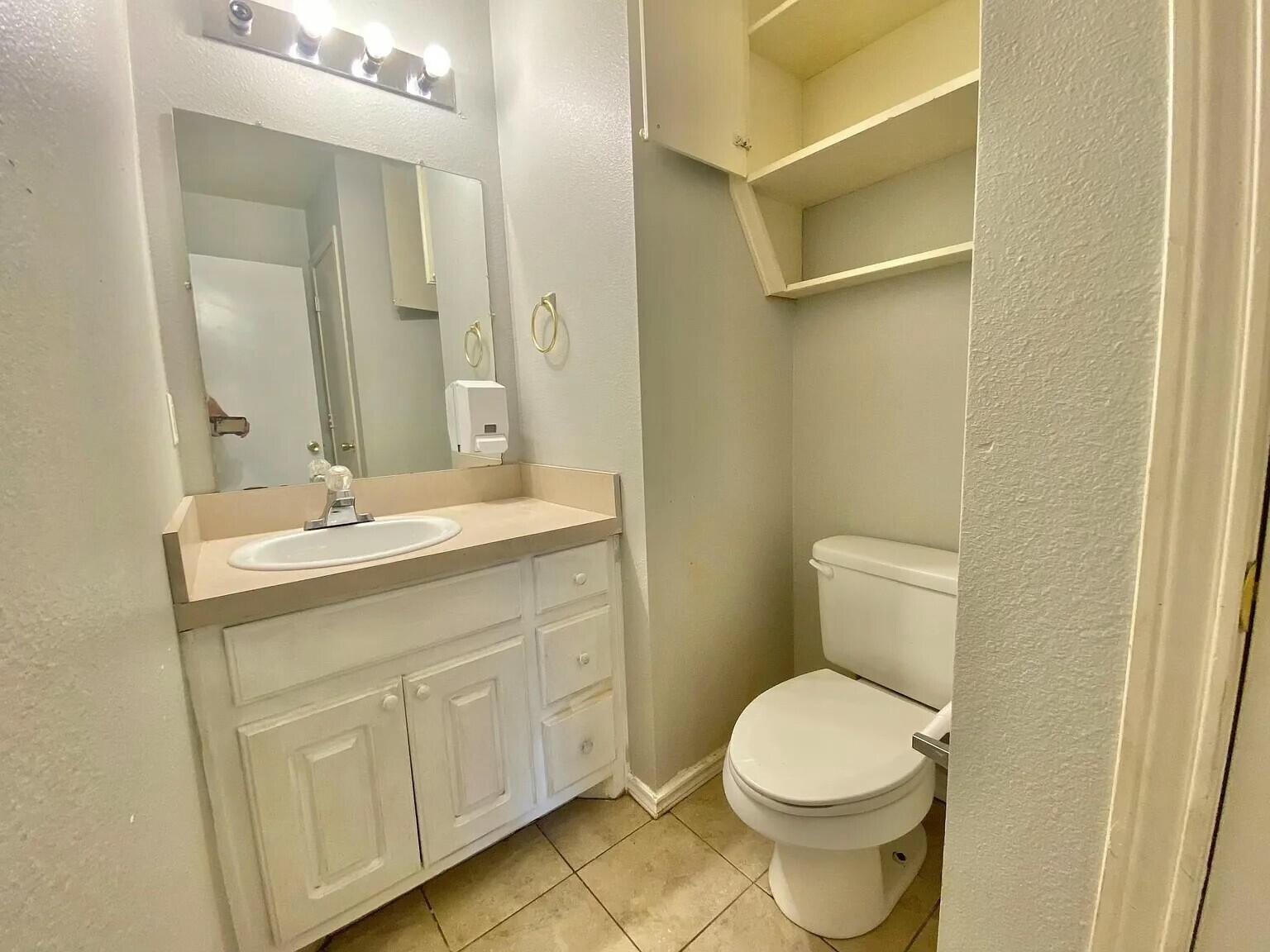 3508 East Colgate Street Lubbock, TX 79403 - Photo 7 of 38 a bathroom with a toilet a sink a vanity and mirror