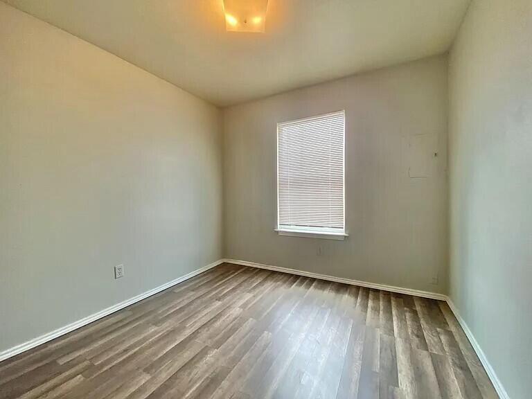 3508 East Colgate Street Lubbock, TX 79403 - Photo 8 of 38 an empty room with wooden floor and windows