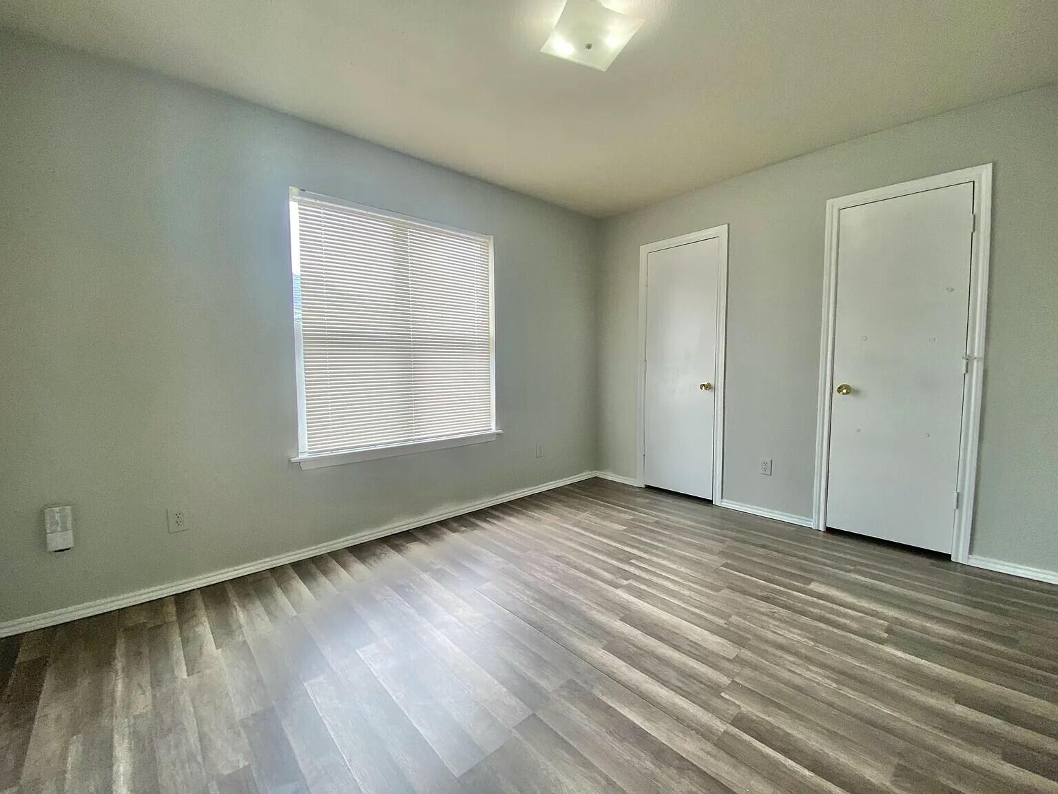 3508 East Colgate Street Lubbock, TX 79403 - Photo 9 of 38 an empty room with wooden floor and windows