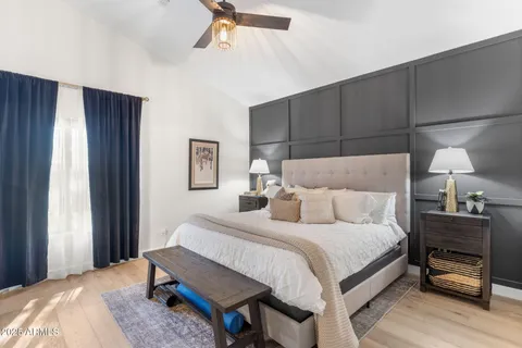 a bedroom with a bed and a lamp on dresser