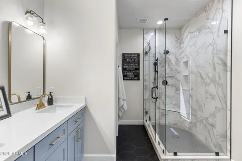 a bathroom with a shower sink and mirror