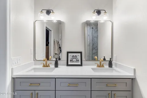 a bathroom with double vanity sinks and a mirror