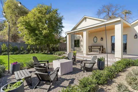 a view of a patio with chairs and a small yard