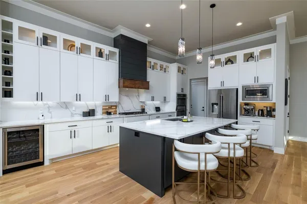 a kitchen with a sink stove cabinets and wooden floor