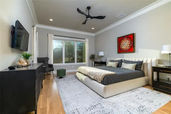 a bedroom with a large bed and a flat tv screen on dresser