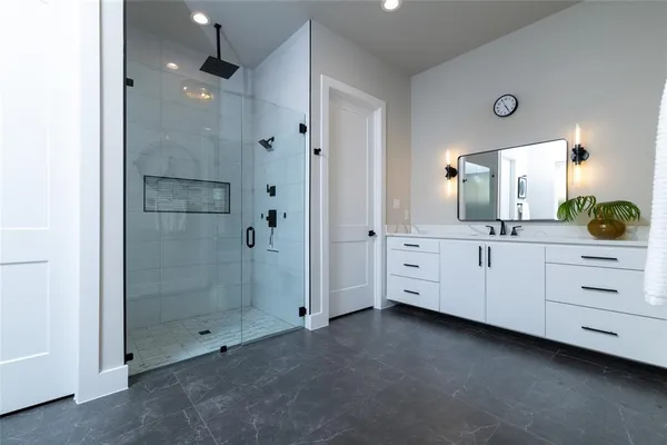 a spacious bathroom with a shower sink and mirror