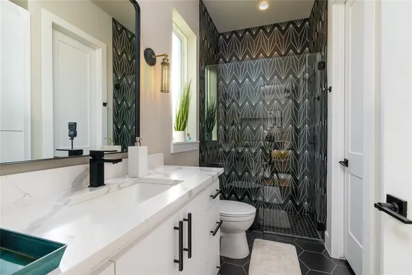 a bathroom with a sink a toilet and shower