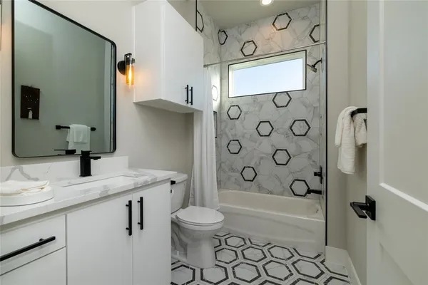 a bathroom with a granite countertop sink a toilet and shower