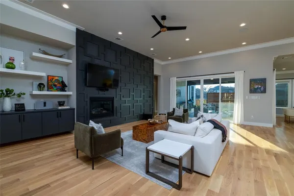 a living room with furniture a fireplace a flat screen tv and a large window