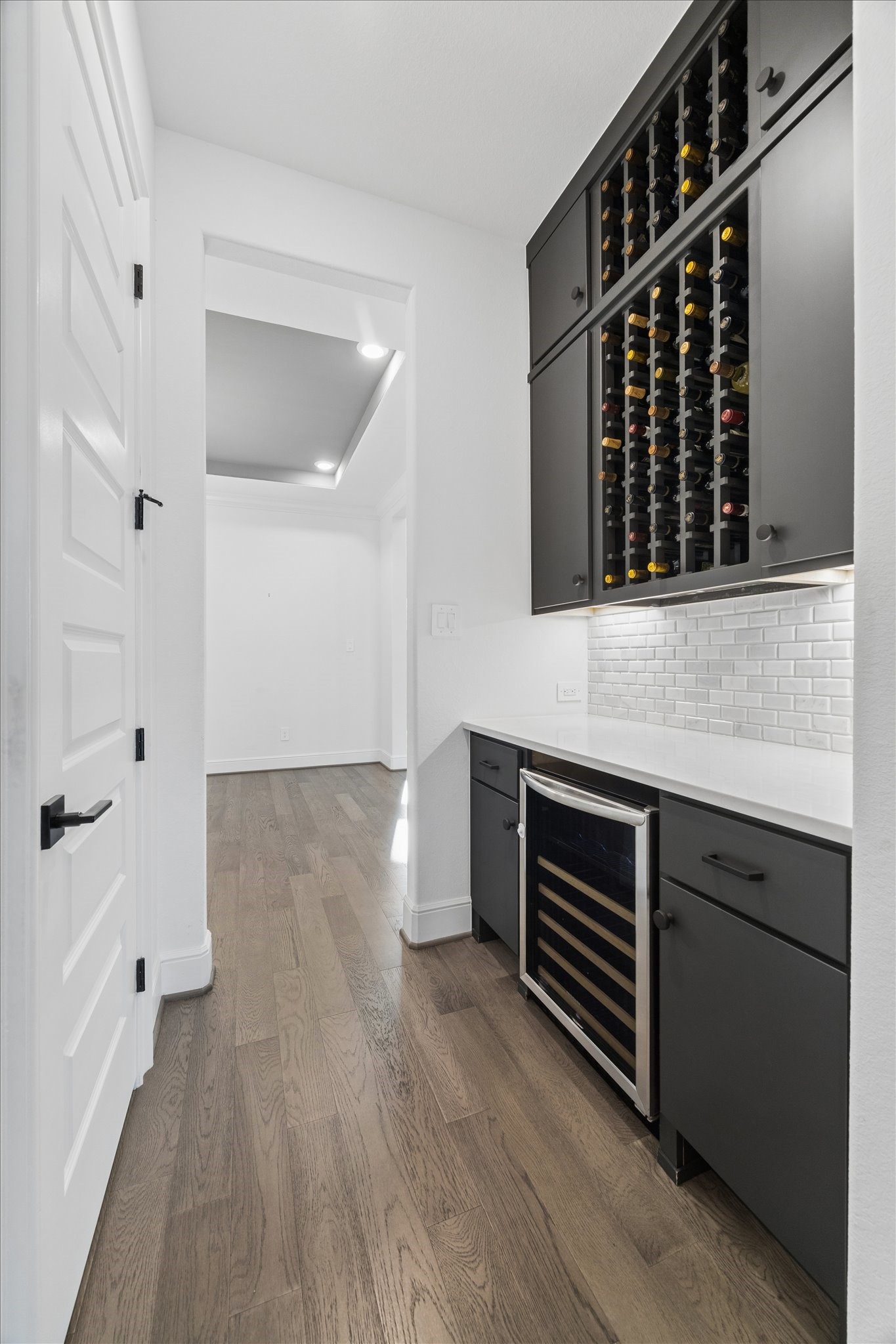 28015 Royal Swan Lane Spring, TX 77386 - Photo 12 of 25 Stylish butler’s pantry connecting the dining room and kitchen, featuring built-in wine storage, a wine refrigerator, and additional cabinetry and counter space—perfect for entertaining and convenient serving.