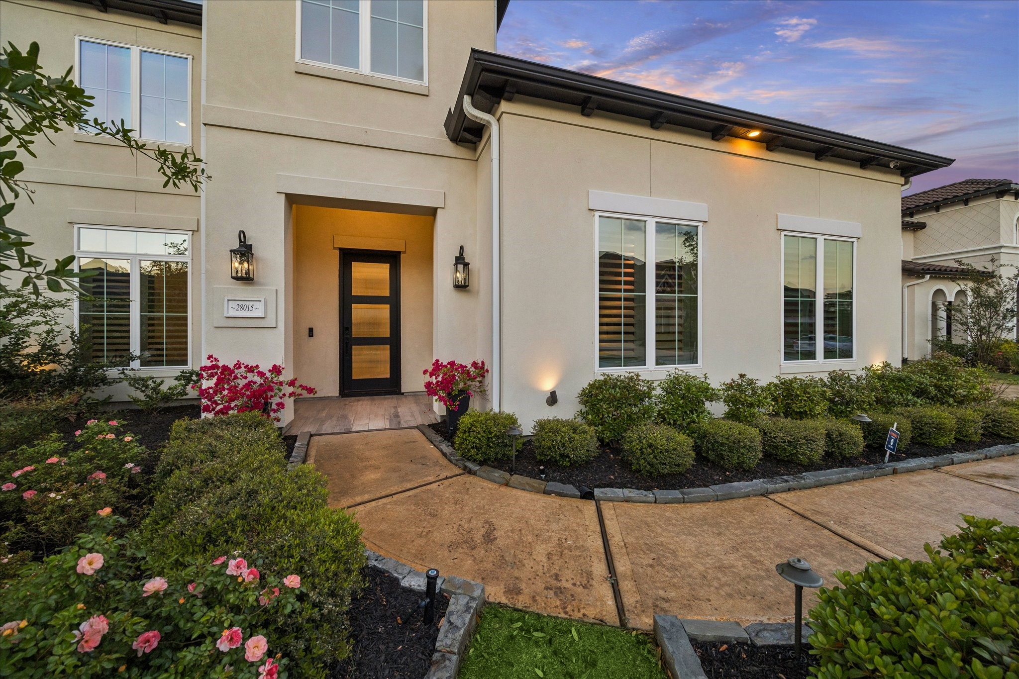 28015 Royal Swan Lane Spring, TX 77386 - Photo 4 of 25 Welcoming front entry featuring a covered porch, elegant lighting, and beautifully maintained landscaping that creates a warm and inviting arrival experience.